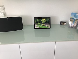 Tablet auf Sideboard zeigt Kamerabild vom Garten
